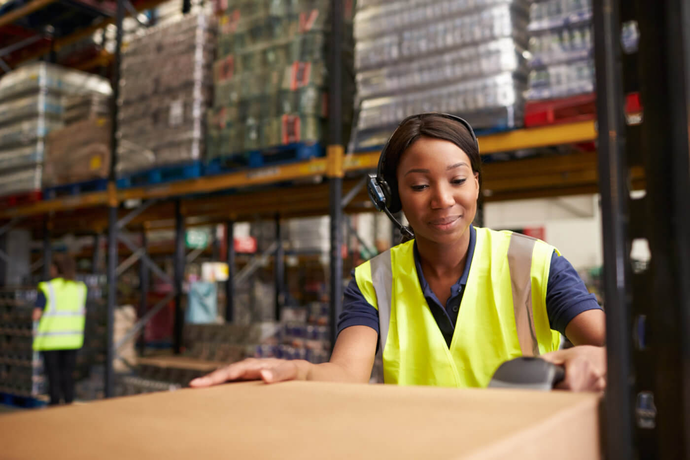 Woman using a barcode reader in a distribution warehouse - insurance verification