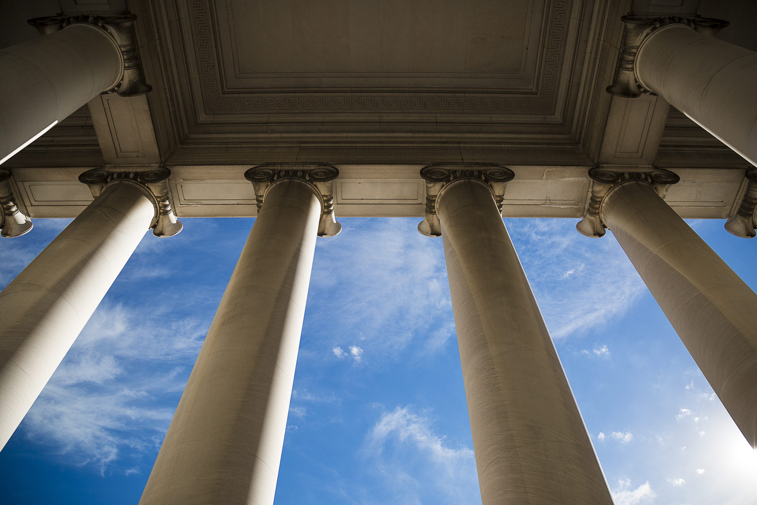 government building with columns against a blue sky